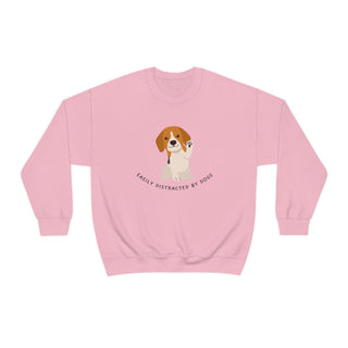 Easily Distracted Unisex Heavy Blend Crewneck Sweatshirt in Pink. Shown is front design featuring a dog waving with the saying "Easily Distracted by Dogs" below it. The back of shirt has the classic Benefit Beagle Logo.