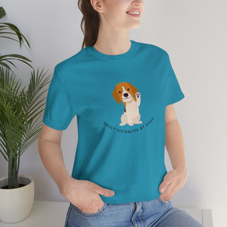 Easily Distracted Unisex Jersey Short Sleeve Tee in Aqua. Shown is front design featuring a dog waving with the saying "Easily Distracted by Dogs" below it. The back of shirt has the classic Benefit Beagle Logo.