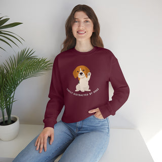 Easily Distracted Unisex Heavy Blend Crewneck Sweatshirt in Maroon. Shown is front design featuring a dog waving with the saying "Easily Distracted by Dogs" below it. The back of shirt has the classic Benefit Beagle Logo.