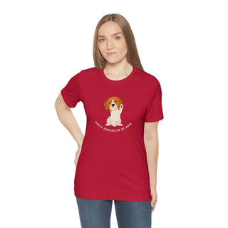 Easily Distracted Unisex Jersey Short Sleeve Tee in Red. Shown is front design featuring a dog waving with the saying "Easily Distracted by Dogs" below it. The back of shirt has the classic Benefit Beagle Logo.