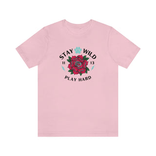 Stay Wild Unisex Premium Tee in Pink. Shown is front of Stay Wild Design features a tattoo style rose with the phrase "Stay Wild, Play Hard" around it. The back of shirt features the Stay Wild Benefit Beagle Logo Design.