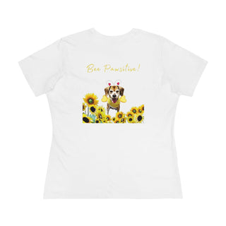 Bee Pawsitive Women's Premium Tee in White. Shown is back of shirt showcasing a dog dressed as as bee in a a field of sunflowers with the phrase "Bee Pawsitive!" above it. The front features the Bee Pawsitive Benefit Beagle Logo.