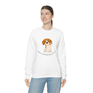 Easily Distracted Unisex Heavy Blend Crewneck Sweatshirt in White. Shown is front design featuring a dog waving with the saying "Easily Distracted by Dogs" below it. The back of shirt has the classic Benefit Beagle Logo.