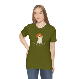 Easily Distracted Unisex Jersey Short Sleeve Tee in Olive. Shown is front design featuring a dog waving with the saying "Easily Distracted by Dogs" below it. The back of shirt has the classic Benefit Beagle Logo.