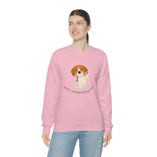 Easily Distracted Unisex Heavy Blend Crewneck Sweatshirt in Pink. Shown is front design featuring a dog waving with the saying "Easily Distracted by Dogs" below it. The back of shirt has the classic Benefit Beagle Logo.