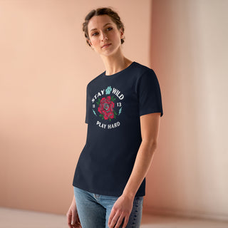 Stay Wild Women's Premium Tee in Navy. Shown is front of Stay Wild Design features a tattoo style rose with the phrase "Stay Wild, Play Hard" around it. The back of shirt features the Stay Wild Benefit Beagle Logo Design.