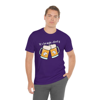 Beagle-Thirty Mugs Unisex Jersey Short Sleeve Tee in Team Purple. The front of shirt showcases Two Dog Adorned Mugs clinking with the saying, "It's Beagle-Thirty" above it. Back of shirt features corresponding Benefit Beagle Logo.