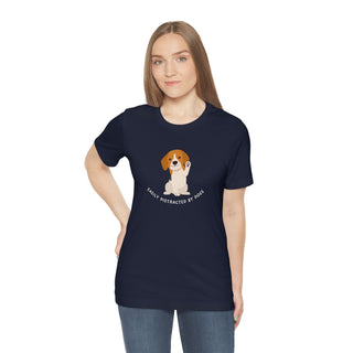 Easily Distracted Unisex Jersey Short Sleeve Tee in Navy. Shown is front design featuring a dog waving with the saying "Easily Distracted by Dogs" below it. The back of shirt has the classic Benefit Beagle Logo.