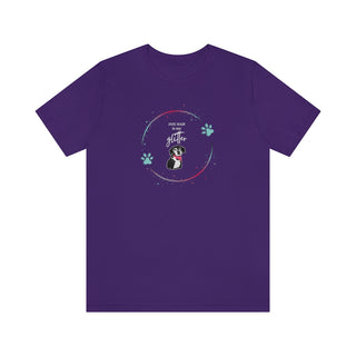 Dog Hair is my Glitter Unisex Jersey Short Sleeve Tee in Team Purple. The Dog Hair is my Glitter design features a dog with the phrase "Dog Hair is my Glitter" above it and it is surrounded by a circle with paw prints.