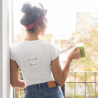 Live in the Moment Women's Softstyle Tee in White. The Live in the Moment design features a graphic on the back with the phrase "Live in the Moment" surrounded by shooting stars.