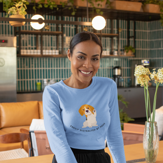 Easily Distracted Ultra Cotton Long Sleeve Tee in Carolina Blue. Shown is front design featuring a dog waving with the saying "Easily Distracted by Dogs" below it. The back of shirt has the classic Benefit Beagle Logo.